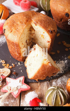 Weihnachten Panettone Brot mit Trockenfrüchten und festliche Dekoration Nahaufnahme auf dem Tisch. Vertikal Stockfoto