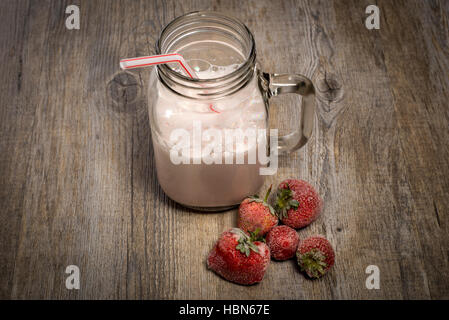 Erdbeerproteinmilch in einem Marmeladenglas schütteln. Stockfoto