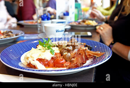 Warmes Frühstück Wurst Parma Schinken Tomaten Rührei und Pilze in einem Carluccio restaurant Stockfoto