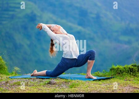 Sportlich Fit Frau Praktiken Yoga Asana Anjaneyasana in Bergen Stockfoto