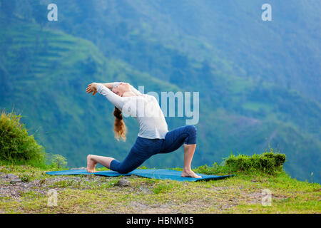 Sportlich Fit Frau Praktiken Yoga Asana Anjaneyasana in Bergen Stockfoto