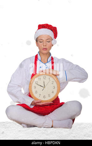 Koch in Nikolausmütze, Yoga Uhr unter Schnee Stockfoto