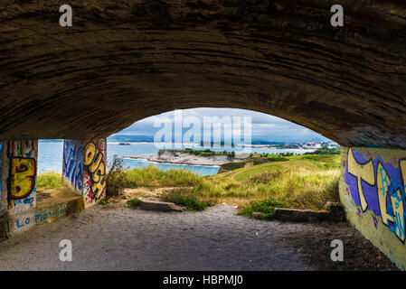 Bunker mit Graffiti an der Sicht des Cabo Mayor. Felsenküste entlang der Klippen mit Menschen Flanieren in Santander, Kantabrien, Spanien Stockfoto