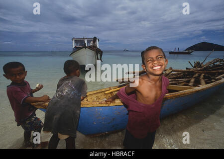 Lokalen Dorf Familie entladen Holz vom Boot, Yaqeta Island. Yasawa-Gruppe. Fidschi-Inseln. Süd Pazifik Stockfoto