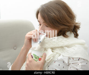 junge Frau leidet unter einer Erkältung und Tee trinken Stockfoto