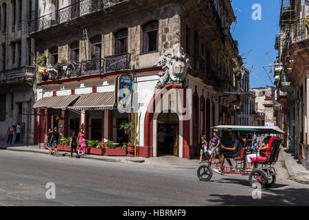 Ein Bicitaxi Zyklen vor dem Castillo de Farnes Resaurant in Havanna, beleuchtet durch die starke Sonneneinstrahlung der Karibik. Stockfoto