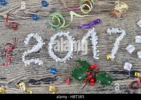 Jahr 2017 weißen Lametta auf einem alten bemalten hölzernen Hintergrund mit Weihnachten Spielzeug Stockfoto