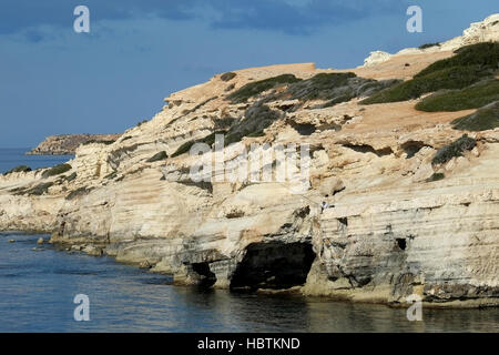 Ein Mann Fische aus den Felsen am Meer Höhlen in der Nähe von Peyia im Bezirk Paphos. Stockfoto