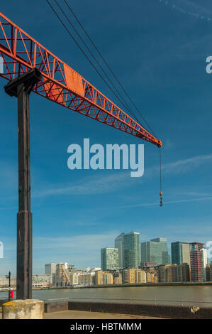 Alter Kran am Ufer der Themse in London Docklands Rotherhithe. Mit Canary Wharf Tower. Stockfoto