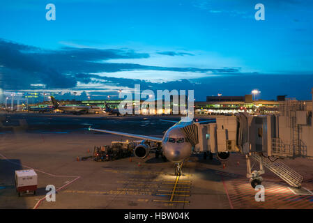 Flugzeuge am Singapore Changi International Airport terminal mit Sonnenaufgang. Stockfoto