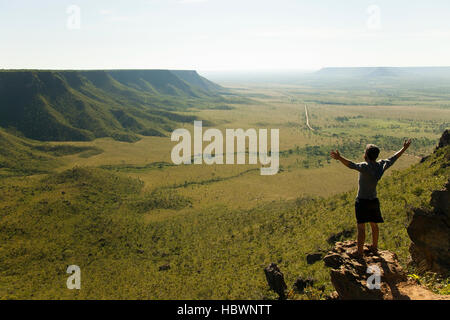 Ein junger Mann mit offenen Armen weit gegen den Wind bewundert Berge Landschaft auf den Sonnenaufgang in Jalapao Stockfoto