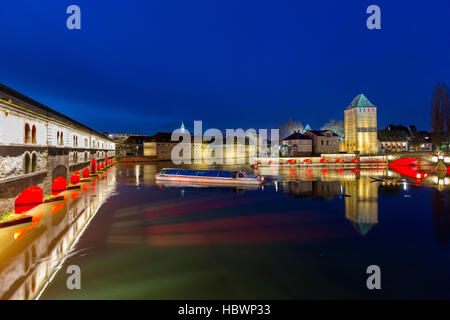 Ausflugsschiff mit Touristen vor der Barrage Vauban und Ponts Couverts nachts entlang dem Fluss Ill, Straßburg, Elsass, Frankreich Stockfoto