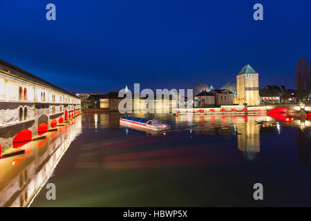 Ausflugsschiff mit Touristen vor der Barrage Vauban und Ponts Couverts nachts entlang dem Fluss Ill, Straßburg, Elsass, Frankreich Stockfoto