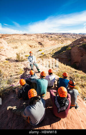 Eine weibliche outdoor Pädagogin lehrt eine Gruppe von männlichen Studenten wie Rappell in der Wüste Canyons von Utah. Stockfoto