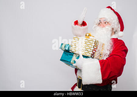 Porträt von fröhlichen Santa Claus Weihnachten holding präsentiert vor weißem Hintergrund Stockfoto