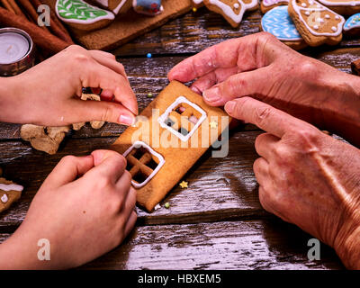 Die Familie machte ein Lebkuchenhaus zu Weihnachten. Stockfoto