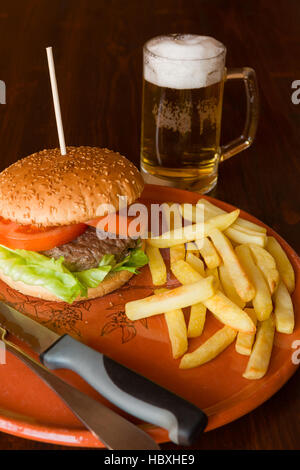 Hamburger gebraten Kartoffeln und Bier Stockfoto