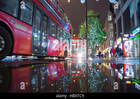 LONDON - 16. November 2016: Roten Doppeldecker-Bus mit Urlaub Lichter reflektiert, wie Fußgänger drängen sich Regent Street. Stockfoto