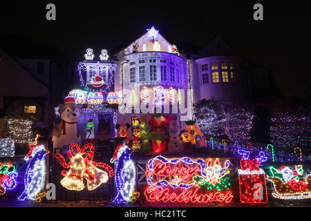 Ein Wohnhaus mit Weihnachtsbeleuchtung und festliche Comicfiguren in Highgate, Nord-London eingerichtet. Stockfoto