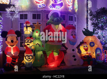 Ein Wohnhaus mit Weihnachtsbeleuchtung und festliche Comicfiguren in Highgate, Nord-London eingerichtet. Stockfoto