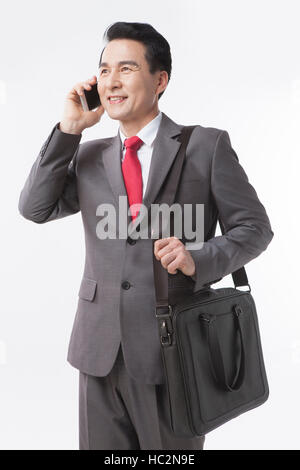 Lächelnd Mitte im Alter Geschäftsmann tragen Aktentasche am Handy sprechen Stockfoto