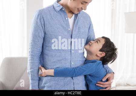 Sechs-Jahr-alten koreanischen jungen umarmt seinen Vater blickte lächelnd Stockfoto