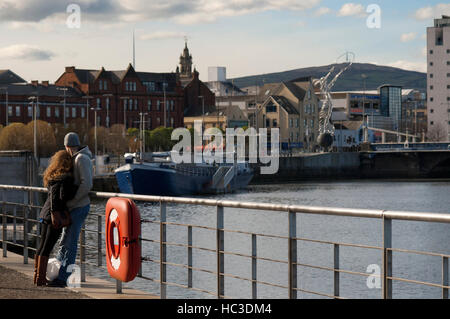 Ein paar in Bridge End, Middlepath Street, A2, Belfast, Nordirland, Vereinigtes Königreich. Das Hafengebiet selbst war schon immer eine romantische und geheimnisvollen Ort, Stockfoto