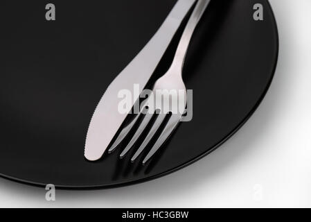 Nahaufnahme von Gabel und Messer auf die schwarze Schale Stockfoto