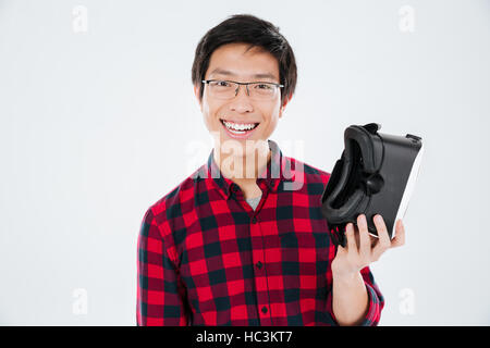 Bild des jungen Mann gekleidet in lässigen Shirt in einem Käfig und virtual-Reality-Haltevorrichtung. Isoliert auf weißem Hintergrund. Stockfoto