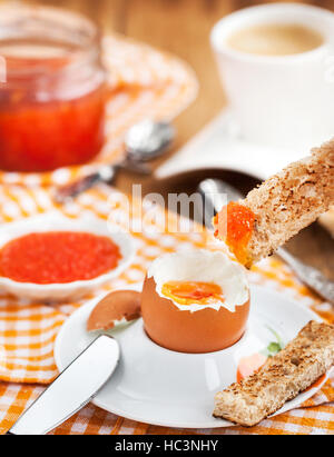 Gekochtes Ei mit rotem Kaviar, Toast und Kaffee zum Frühstück Stockfoto