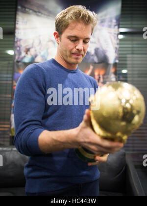 Köln, Deutschland. 7. Dezember 2016. Formel 1 Weltmeister Nico Rosberg blickt auf die Fußball-WM-Trophäe während einer kurzen Treffen des ehemaligen Nationalmannschaft Fußballspielers Lukas Podolski am Flughafen in Köln, Deutschland, 7. Dezember 2016. Foto: Rolf Vennenbernd/Dpa/Alamy Live News Stockfoto