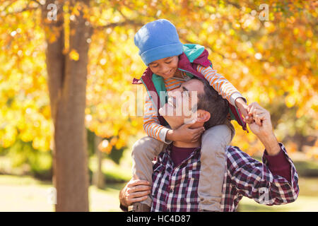 Fröhliche Vater mit Sohn auf Schulter im park Stockfoto