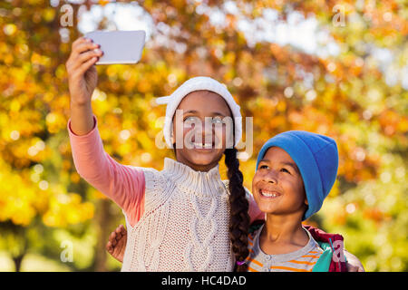 Lächelnde Geschwister nehmen Selfie im park Stockfoto