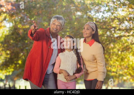 Großmutter zeigt beim stehen mit Tochter und Enkelin im park Stockfoto