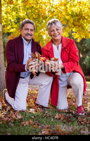 Älteres Paar mit Herbstlaub im park Stockfoto