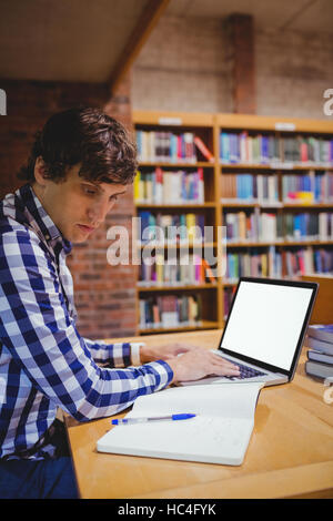 Student mit Laptop in der Bibliothek Stockfoto