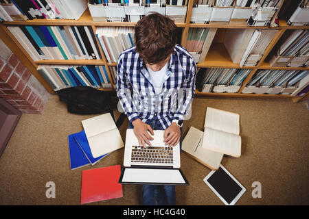 Student mit Laptop in der Bibliothek Stockfoto
