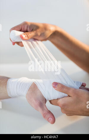 Physiotherapeuten, die männlichen Patienten Hand Bandage anziehen Stockfoto