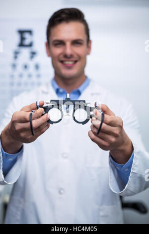 Lächelnd hält Messbrille Augenarzt Stockfoto