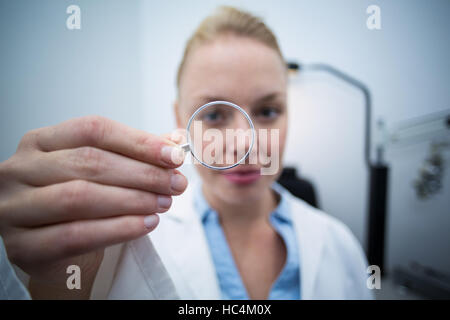 Weiblichen Blick durch die Lupe Optiker Stockfoto