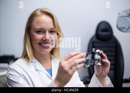 Lächelnde weibliche Optiker halten messbrille Stockfoto