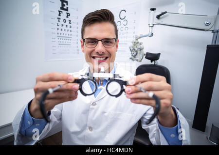 Lächelnd hält Messbrille Augenarzt Stockfoto