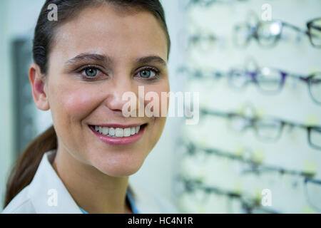 Optiker in Schauspielen lächelnd in optischer Speicher Stockfoto