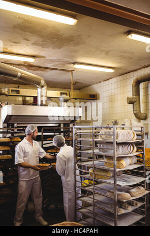 Männliche und weibliche Bäcker arbeiten zusammen Stockfoto