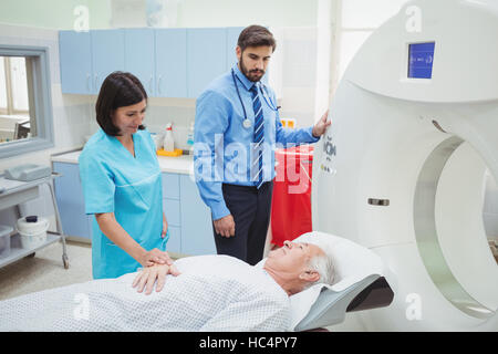 Ein Patient wird in ein MRT-Gerät beim Arzt und Techniker gerade geladen Stockfoto