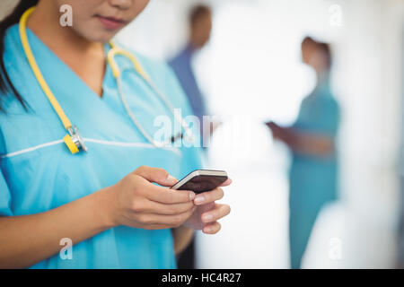 Innenfeldes Krankenschwester Textnachrichten auf dem Handy Stockfoto