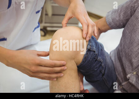 Nahaufnahme der Ärztin untersuchen Patienten Knie Stockfoto