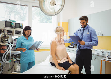 Männlichen Arzt Interaktion mit dem Patienten während der Krankenschwester Blick auf x-ray Stockfoto