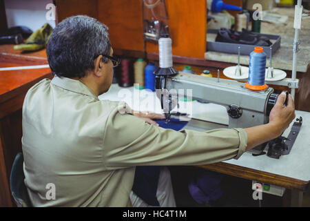 Schuhmacher mit Nähmaschine Stockfoto