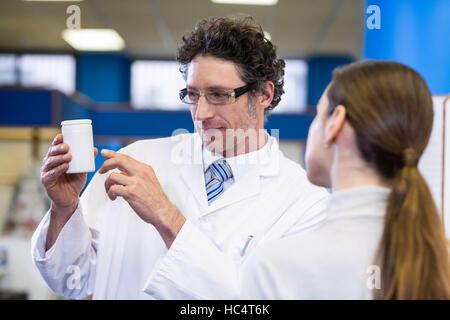 Apotheker unterstützen die Flasche des Medikaments an Kunden Stockfoto